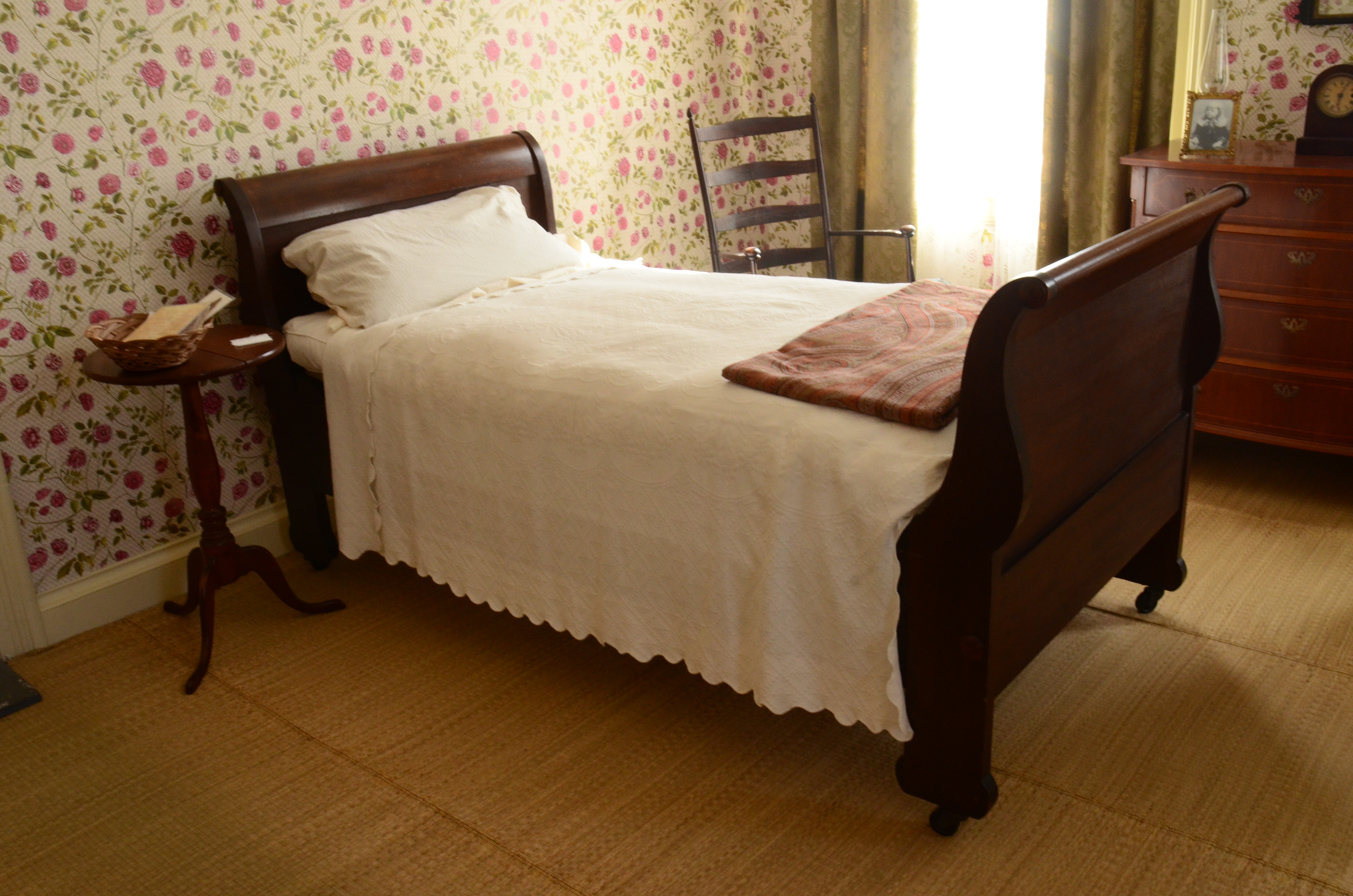Emily's bedroom, with a bed with a wooden frame and white spread