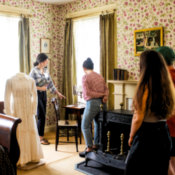 3 people on a tour of Dickinson's bedroom