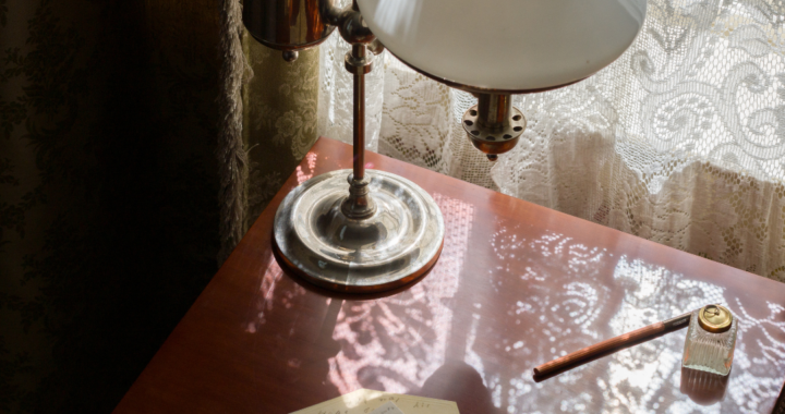 Dickinson's writing desk with pens, scraps of paper and her lamp