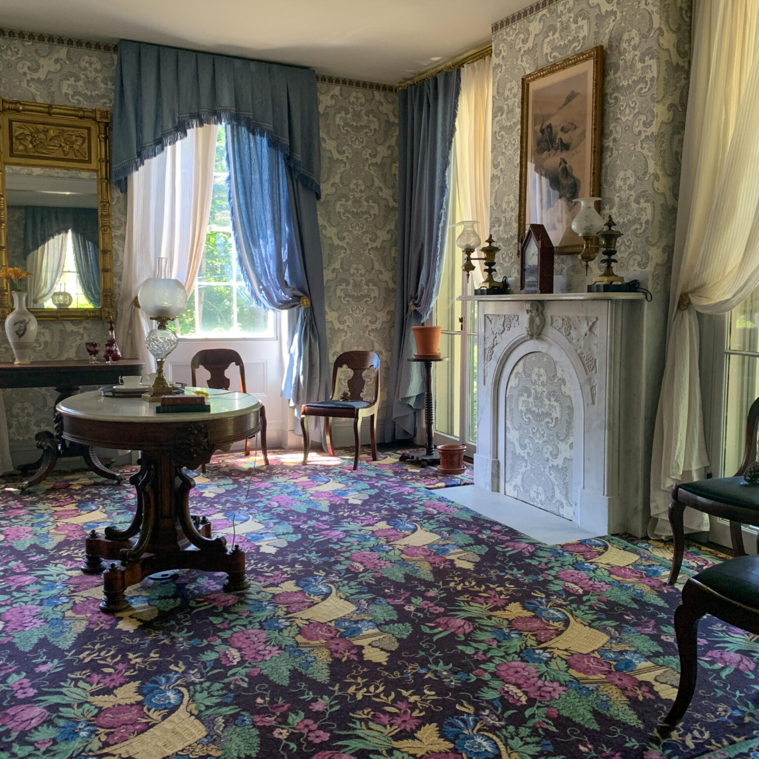 Scene of the Dickinson parlor with floral patterned carpet